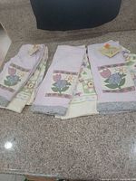 Three folded towels showing embroidery, tags visible