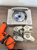 Console open with game disc, controllers and light gun visible