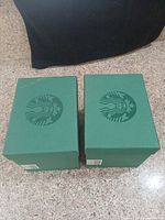 Two green Starbucks boxes closed