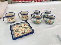 entire set showing six mugs and stacked plates