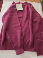 Front view of burgundy turtleneck sweater with tag attached