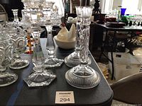 Front view showing both matching pairs of clear glass candlesticks on table