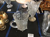 Pitcher, vase and nearby glassware on table