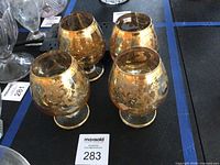 Four gold overlay brandy snifters front view