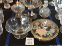 Group view showing six glass pieces including cruet, compote, bowls, lidded dish