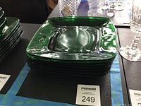 Stack of seven square forest green glass plates