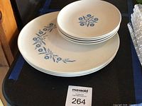 Stack of four small plates resting on four large plates, showing Cornflower design