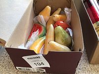 Box containing eight alabaster fruits—three bananas, three pears, one watermelon slice, one strawberry