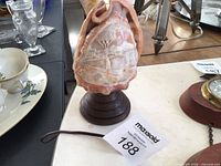 Front view showing carved Mount Vesuvius scene on conch shell lamp with base and tag