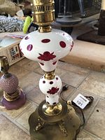 Full view of lamp showing glass body, brass base, and socket