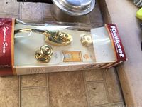 Front view of boxed Kwikset brass handle and knob set