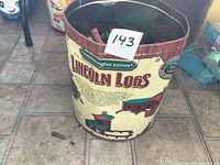 Front of commemorative edition Lincoln Logs tin