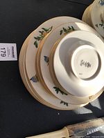 Stack of plates showing floral design and gilt rim