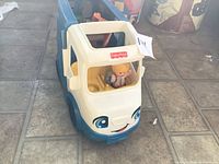Front view of blue and white Little People camper with figure in driver seat