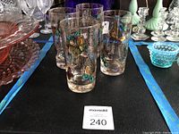 Front view of four tumblers showing butterfly motif and gold speckling