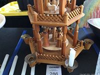 Full view of two-tier wooden German candle pyramid with figures, propeller, and candle holders