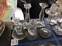 Six clear glass candlesticks on table in normal light