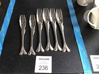 Seven Yamazaki fish forks laid out in a row