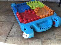 Table folded for rolling, showing multicolour studded surface and handles