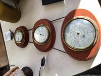 Overall view of the three brass-bezel instruments mounted on wood plaques and joined by chain