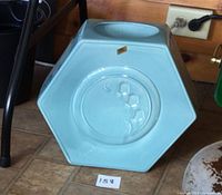 Side view showing hexagonal shape and lily-of-the-valley relief