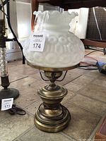 Full view of lamp showing milk glass Moon and Stars shade and brass base