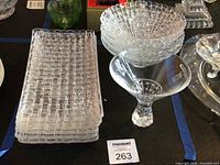 Stack of ten rectangular Bossa Nova plates, martini glass and partial view of bowl