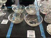 Top and side view of four glass seafood icers with three liners displayed on table