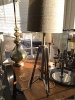 Complete lamp on table showing tripod base and shade