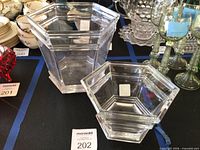 Large and small hexagonal Tiffany crystal vessels on display table