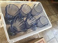 Six blue goblets inside plastic tote