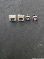 Front view of both earring pairs showing blue stones and CZ halos