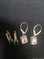 Front view showing both earring pairs on dark background