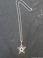 Full view of sterling silver star pendant necklace laid flat