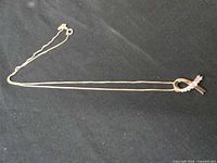 Full view of necklace laid flat showing pendant and chain