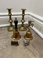 Group shot showing all items: candlesticks, two bells, monkey figurine, pewter mice