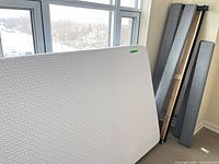 Endy double mattress leaning against window with bed frame rails visible