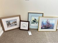 Four framed artworks leaning against wall