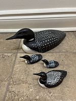 All four carved loon figurines grouped