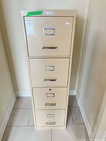 Front view of beige four-drawer metal filing cabinet