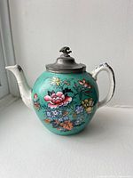 Full view of teapot showing body, spout, handle and pewter lid