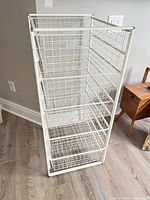 Full view of white metal wire drawer unit standing on floor