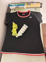 Full view of Yonex T-shirt with shuttlecocks and tube