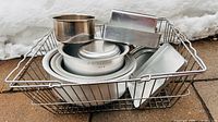 Basket containing assorted metal bowls and pans