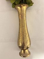 Full view of etched copper vase with artificial flowers inserted