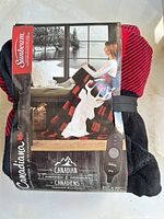 Front of packaged Sunbeam Canadiana heated throw showing branding, pattern, size and controller