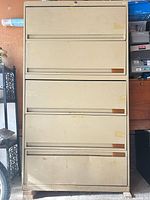 Front view of beige four-drawer metal filing cabinet