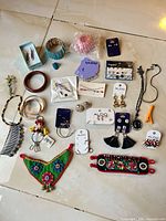 Group shot showing entire lot of 28 assorted jewelry pieces