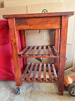 Full view of wooden kitchen island cart with two slatted shelves