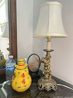 Lamp, ceramic bottle, plaque grouped on table